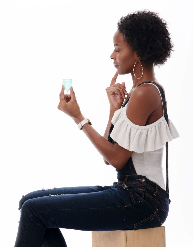 girl holding pixie menstrual cup pondering