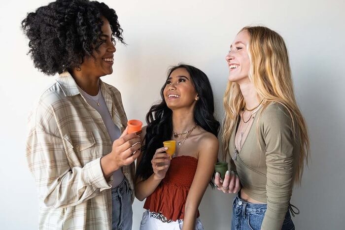 Image of happy women with menstrual cup in their hand