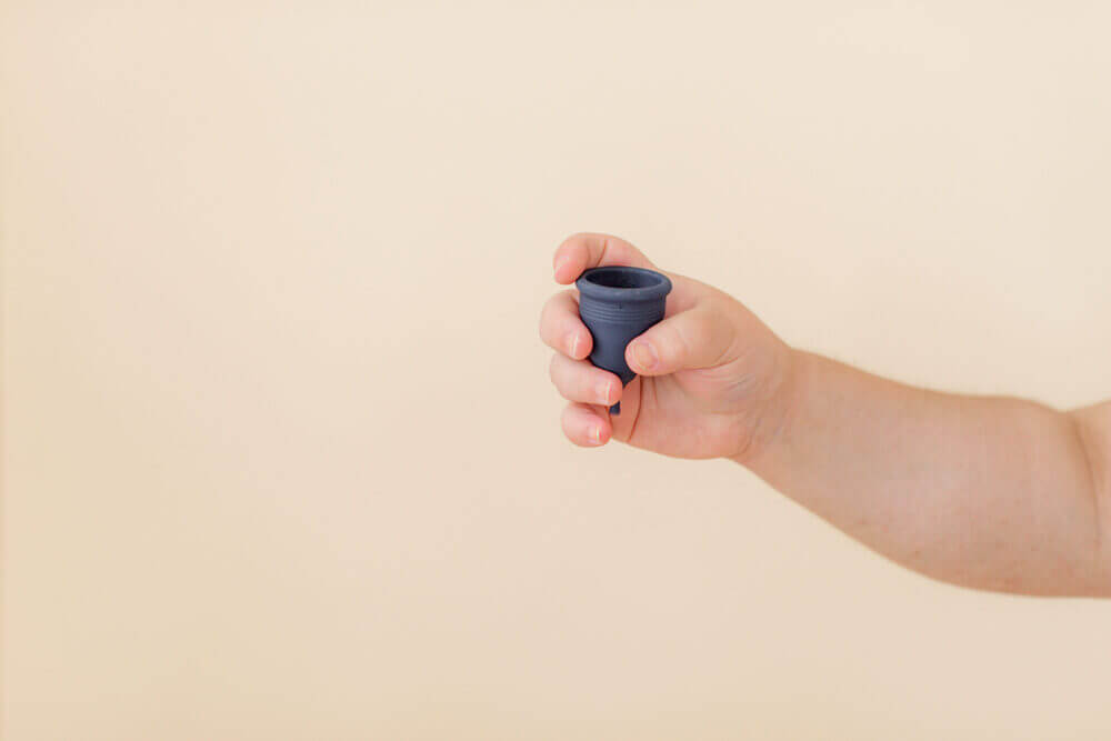 Image of a menstrual cup being held by a woman's hand