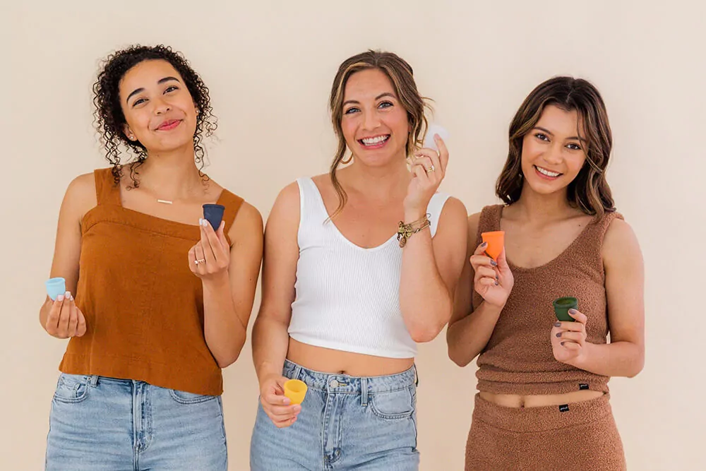 A person holding a menstrual cup up to the light